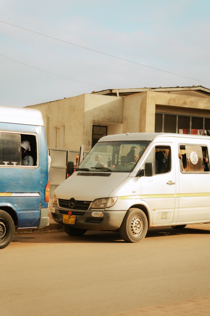 City street view featuring multiple vehicles in traffic, highlighting urban transportation.